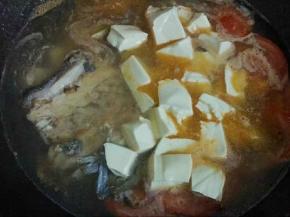 水开后倒入鱼尾，豆腐，加入1勺料酒