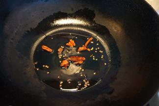 炒锅里倒少许油，将干红辣椒掰碎入油锅中，变成棕色即可