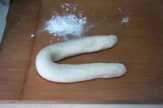 饧好的面团柔软而滋润，从盆中取出放在案上略揉几下，搓成细长条