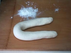 饧好的面团柔软而滋润，从盆中取出放在案上略揉几下，搓成细长条