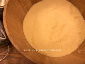 然后，我们准备好木桶蒸。将玉米粉和糯米粉的混合粉再一次筛入木桶中。筛入一层。