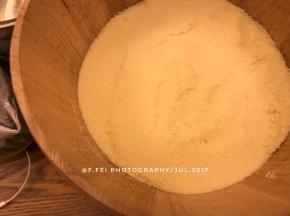 然后，我们准备好木桶蒸。将玉米粉和糯米粉的混合粉再一次筛入木桶中。筛入一层。