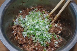 肉馅中加适量生抽、酱油、盐、少量凉水混合均匀；大葱切末，入肉馅中