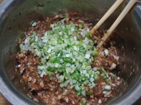 肉馅中加适量生抽、酱油、盐、少量凉水混合均匀；大葱切末，入肉馅中