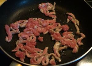 炒锅中倒适量油，油温5成热，将肉丝入锅中，快速用铲子划散开，使肉丝一根根独立不粘连