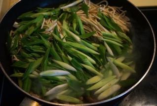 将豆腐丝和青蒜全部倒入锅中，不停翻炒