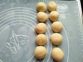 取一个油皮用手掌心压扁；放入油稣包起，收口朝下