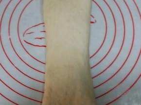 松驰好的面团， 收口朝上，擀长。自上而下卷起。