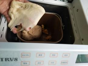 面包桶里先放水、糖和盐对角分开放、放高筋面粉和全麦粉，最后放酵母，启动一个揉面程序，加入软化的黄油；能拉出结实的膜即可