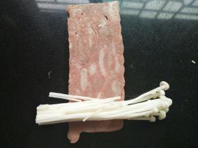 取一片培根肉，放少量的金针菇