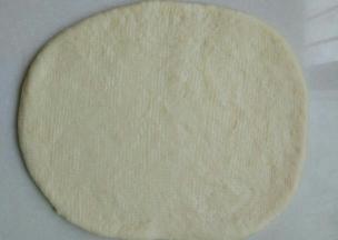 取出白色面团擀成椭圆形或者长方形。