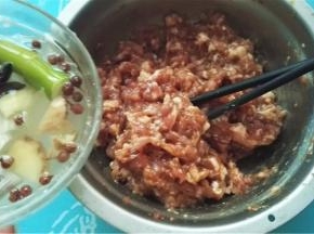 肉馅放入容器内，一边加入葱姜汁，一边搅拌肉馅；