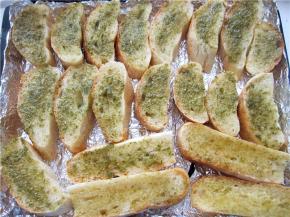 将面包片摆放在烤盘里，涂抹上调制好的调料；