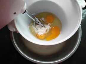 鸡蛋打入容器里加全部的细砂糖，坐热水盆打发