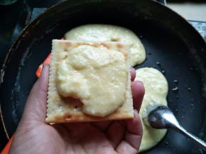 取一片苏打饼干，用勺子舀点牛扎馅