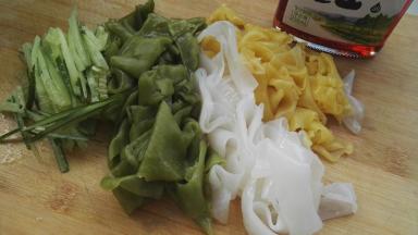 把凉皮放案板上切成条，黄瓜切丝。