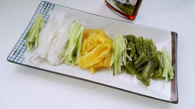 把三色凉皮、黄瓜丝放盘中。