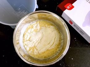 筛入展艺班戟预拌粉。最后剩余的是砂糖，也倒回盆中。