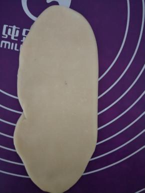 再从中间向上向下擀开，擀成长舌状