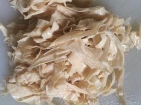 焯烫好的豆皮，过凉水后，沥去水分，改刀切成细丝。