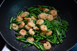 把炒好的虾仁倒进锅里一起炒，最后淋点油出锅