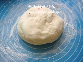 余下的高筋面粉20g洒在案板上，将面团放在上面