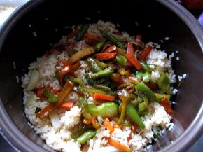 再将加入青椒的蔬菜倒入电饭煲中，盖盖焖制10分钟，即可食用啦。