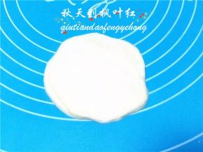 取一份面团轻轻按扁。