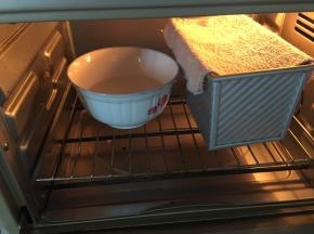 烤箱内放一碗水，吐司盒盖上湿布或者保鲜膜进行发酵，发酵时长45分钟