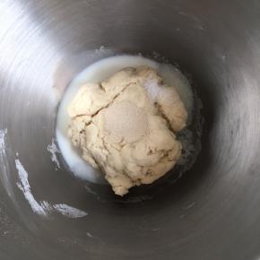 将除黄油以外的其他材料倒入厨师机内（注意剩下的牛奶不要一次性倒完，根据面团干湿程度来加），盐和酵母不要混合在一起，对角线放置盐和糖，酵母放中间