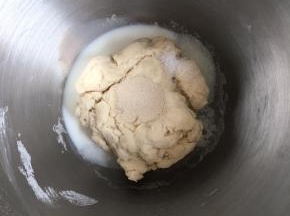 将除黄油以外的其他材料倒入厨师机内（注意剩下的牛奶不要一次性倒完，根据面团干湿程度来加），盐和酵母不要混合在一起，对角线放置盐和糖，酵母放中间