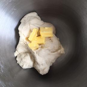 分次加入软化的黄油，继续厨师机揉面