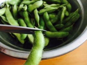 毛豆用淡盐水泡10分钟，用双手搓洗毛豆数次。
为了让毛豆更好的入味，用剪子在毛豆梗的一端剪个小口。
