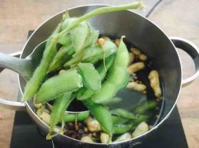 碧绿的毛豆煮好了
为了入味需要在锅里浸泡数个小时
如果你喜欢冰冰的透心凉的毛豆，你就等毛豆凉了以后，把它盛在保鲜盒里放在冰箱里冷藏数个小时入味。