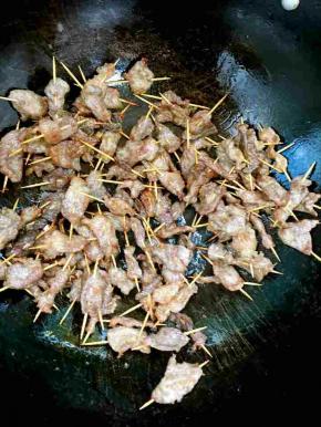 重新起锅，烧热倒入少许的油，放入炸好的牙签肉翻炒均匀。

