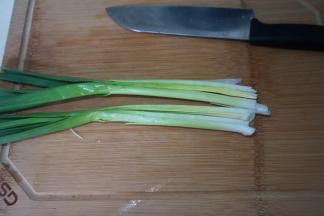 青蒜洗干净，特别要将叶片与杆之间的位置掰开冲洗，纵切两半，用刀拍扁