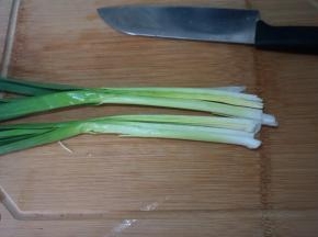 青蒜洗干净，特别要将叶片与杆之间的位置掰开冲洗，纵切两半，用刀拍扁