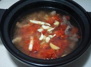 将西红柿倒入牛肉砂锅内，再加够足量的热水，将大蒜瓣、姜片同入锅中；我用的电炖锅，选择“红烧牛羊”的程序，时间设为2个半小时