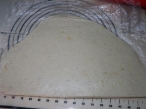 剪开一个保鲜袋，效果比保鲜膜要好，将土豆泥团放在保鲜袋上，对折一下，擀成厚约8毫米左右的片