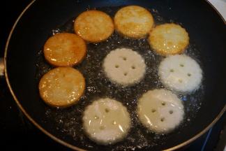 平底煎锅中倒适量油，将土豆饼放入锅中，中小火煎炸至两面金黄