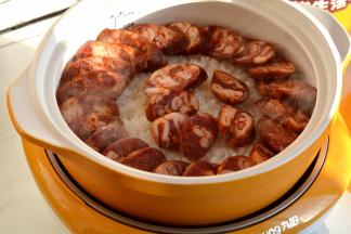 沿着锅边淋少许橄榄油，再将腊肠均匀铺摆在饭上；喜欢重口味，可以淋些酱油、生抽；再码放好南瓜片，西兰花和口蘑片只撒少许，留一半出锅时再撒，因为焯过水，可以直接食用的，再磕一个鸡蛋在上面