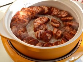 沿着锅边淋少许橄榄油，再将腊肠均匀铺摆在饭上；喜欢重口味，可以淋些酱油、生抽；再码放好南瓜片，西兰花和口蘑片只撒少许，留一半出锅时再撒，因为焯过水，可以直接食用的，再磕一个鸡蛋在上面