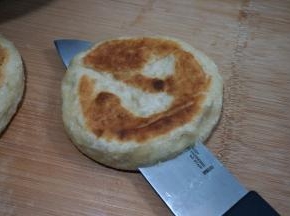 取一个面饼，用刀横切成两半，但是末端不要切断，保持连着的状态