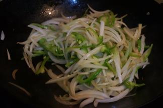 炒锅中倒少许油，将洋葱和尖椒断生，盛出备用