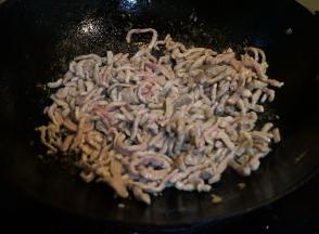 炒锅中重新倒入适量油，油到5、6成热时，转小火，将肉丝倒入锅中，用铲子尖儿迅速划散，等肉丝条条分明时，转大火炒熟