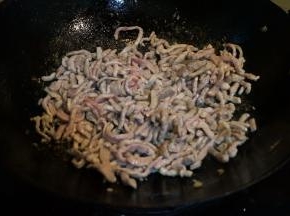 炒锅中重新倒入适量油，油到5、6成热时，转小火，将肉丝倒入锅中，用铲子尖儿迅速划散，等肉丝条条分明时，转大火炒熟