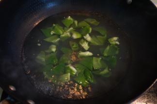 锅中坐水，将青椒块在开水中冒一下就捞出