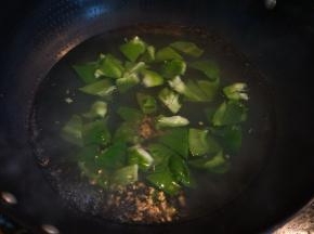 锅中坐水，将青椒块在开水中冒一下就捞出