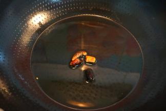 炒锅中倒适量油，将干红辣椒煸成褐色