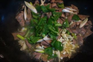 再倒入青椒块、大蒜末翻炒